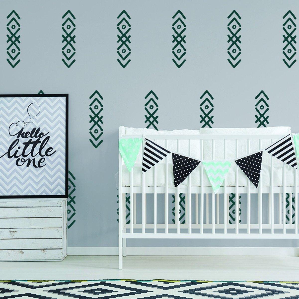 Stylish nursery featuring arrow wall stickers, crib, and decorative bunting for a charming and playful design.