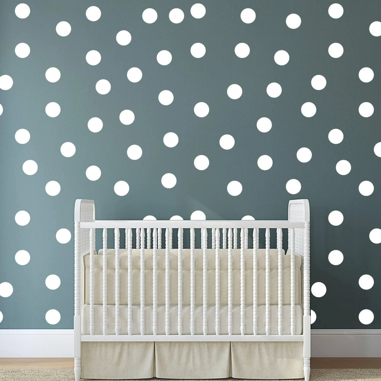 White round circle dot stickers on a dark wall with a white crib in a cozy nursery.