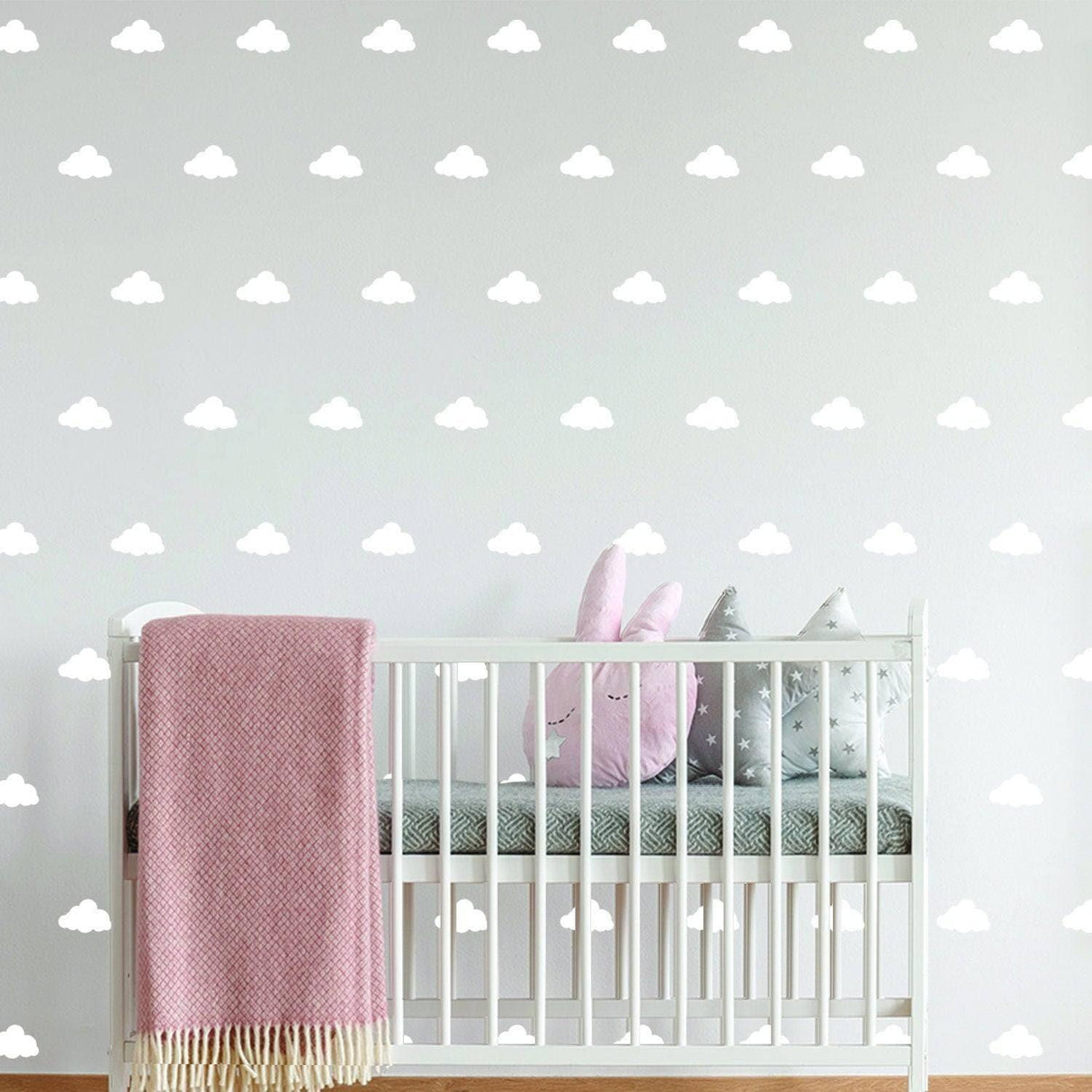 WhimsiCloud children's wall stickers featuring soft clouds in a nursery with a crib and plush toys.