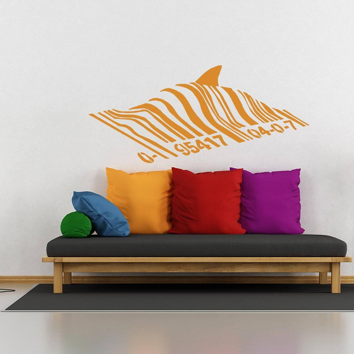 Banksy Barcode Shark wall sticker above a stylish couch with colorful pillows, showcasing urban art decor for home.