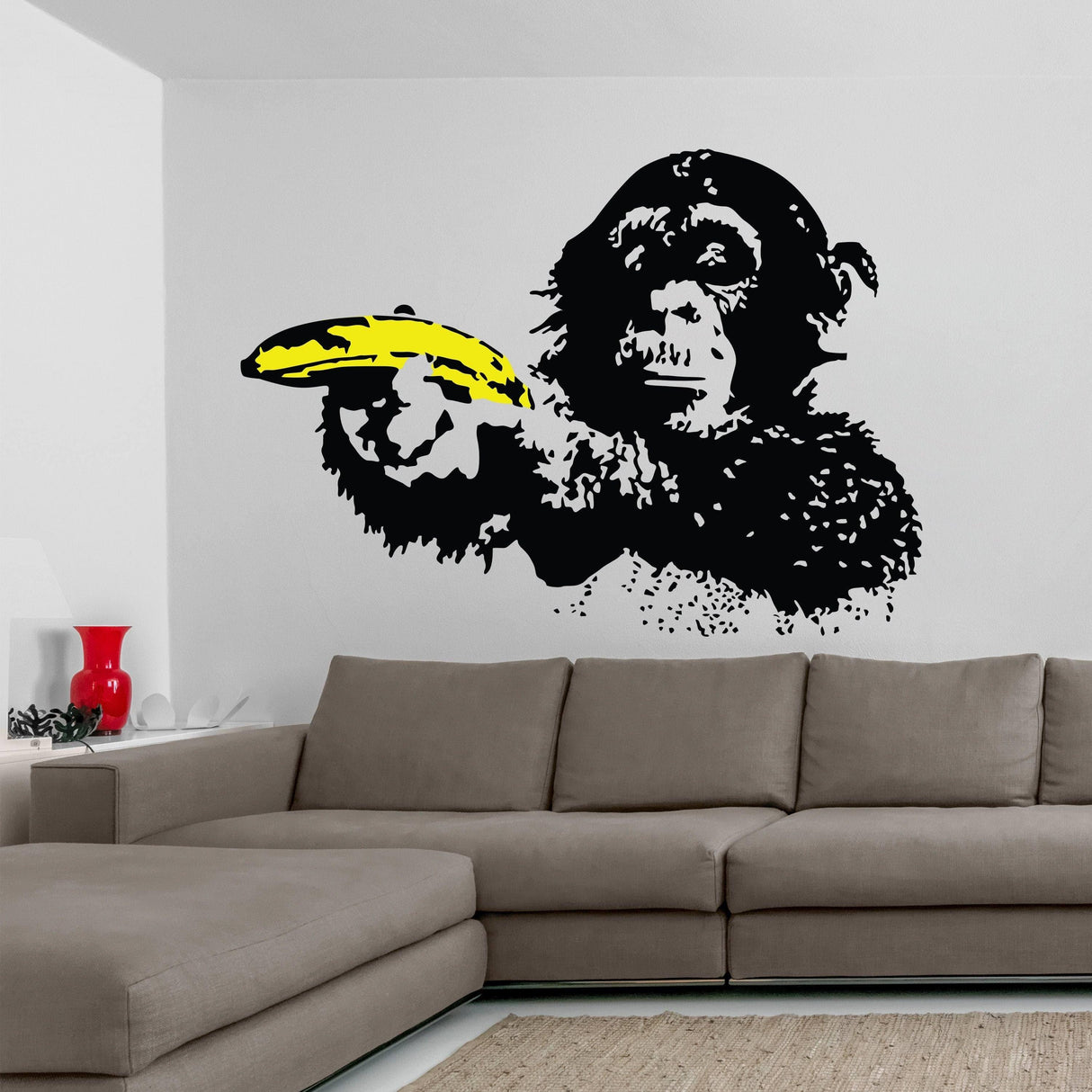 Vibrant Banksy-style monkey wall decal with a banana in a modern living room setting.