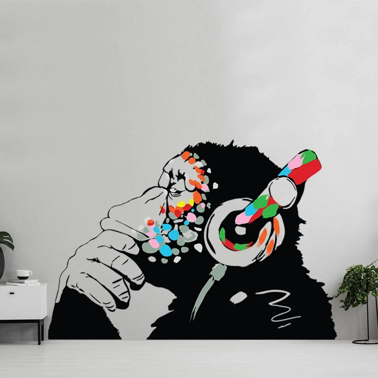 Banksy-inspired wall decal of a thoughtful monkey wearing colorful headphones, showcasing modern art charm and style.