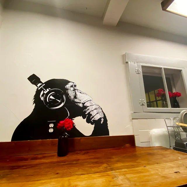 Cool thinking monkey wall sticker with headphones, adding a quirky touch to a modern kitchen.