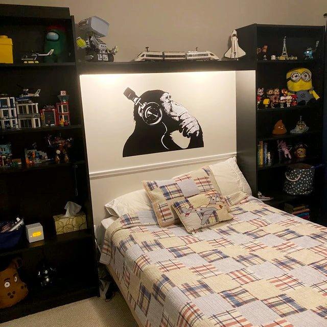 Contemplative chimp wall decal above a cozy bed, enhancing the room's personality with a quirky design.