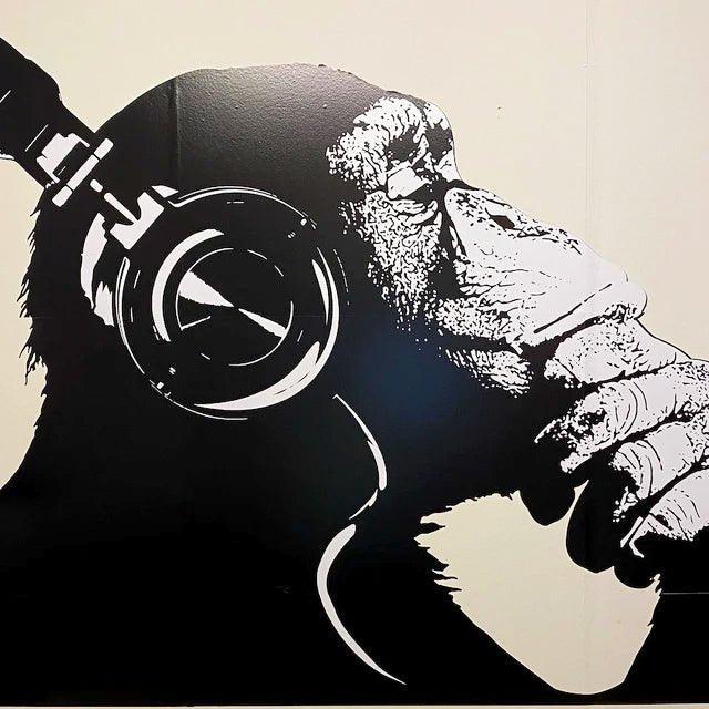 Contemplative chimp wall art decal with headphones, adding personality to any room.
