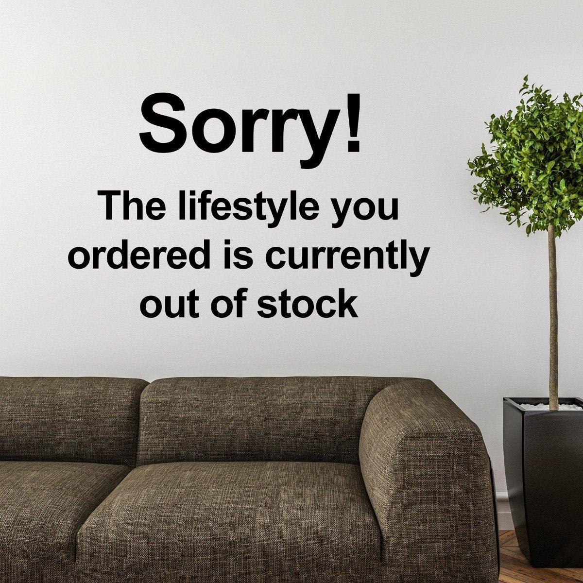 Banksy-inspired wall decal saying 'Sorry! The lifestyle you ordered is currently out of stock' above a modern couch.