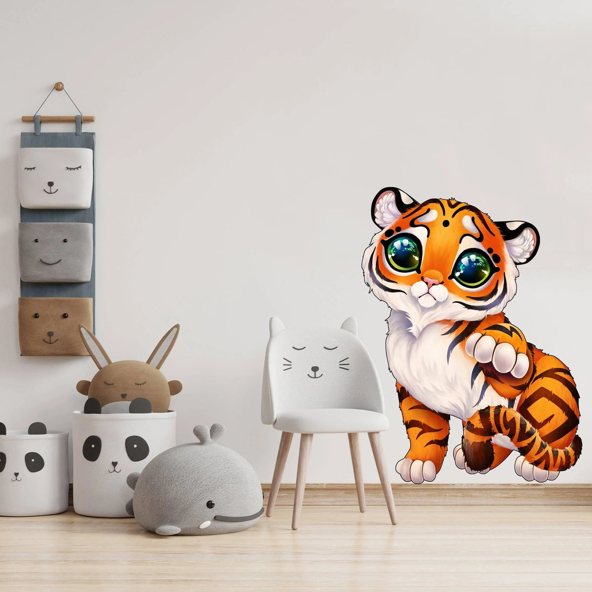 Cute tiger wall decal adding charm to a playful nursery decor with plush toys and a minimalist chair.
