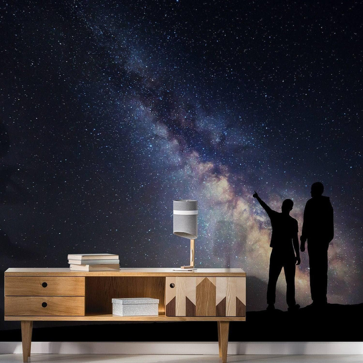 Silhouette of two people admiring the Milky Way against a starry sky, enhancing a modern living space.