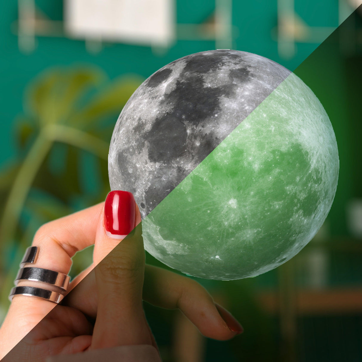 Hand holding a dual-colored moon-shaped decal, one side glowing green, showcasing a playful laptop accent.