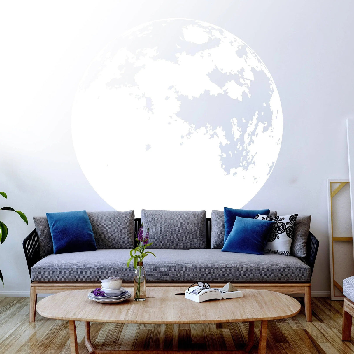 Luminous lunar wall decal glow-in-the-dark moon sticker on living room wall above modern sofa and coffee table.