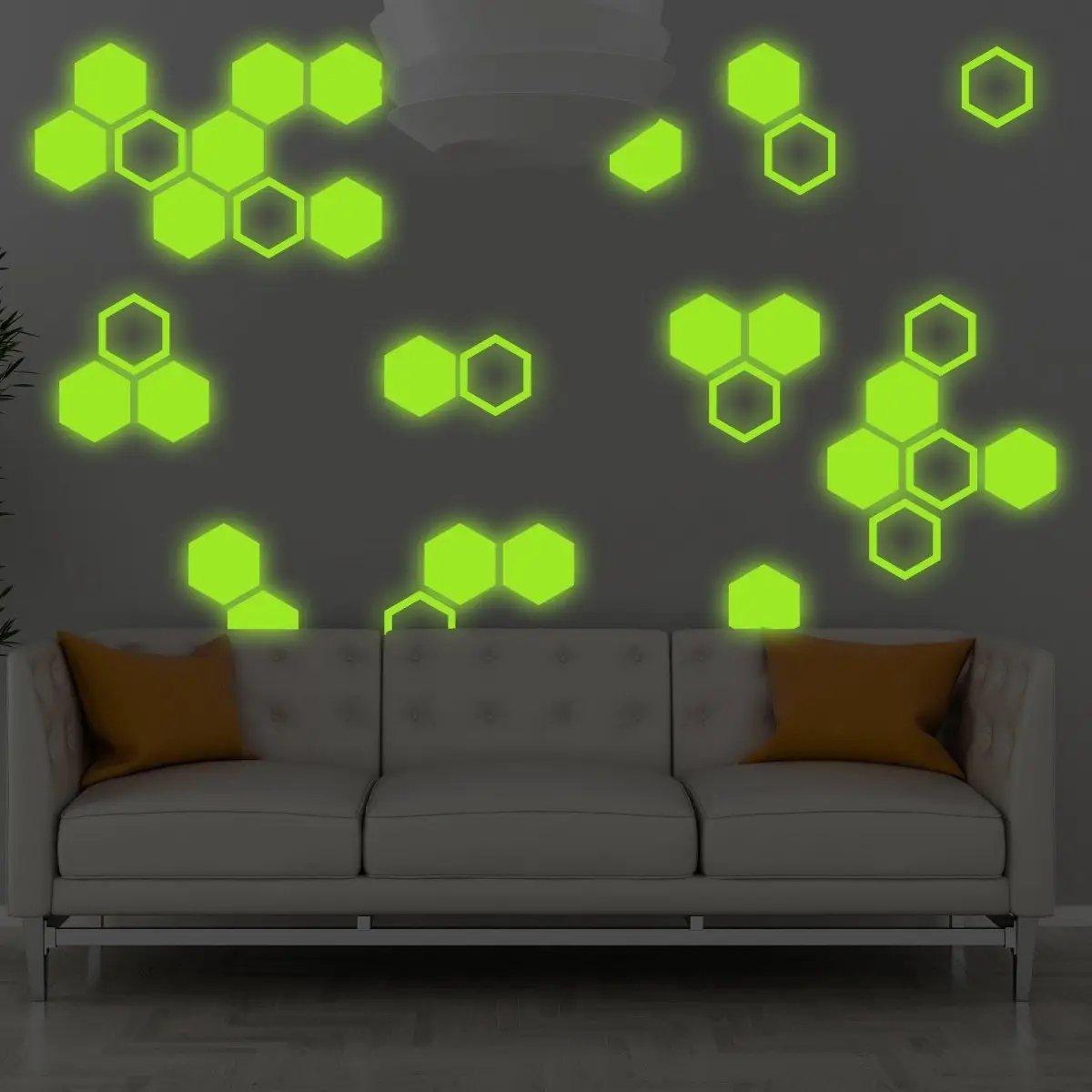 Glow in the dark hexagon wall stickers decorating a room with a modern sofa, adding a whimsical touch to children's spaces.