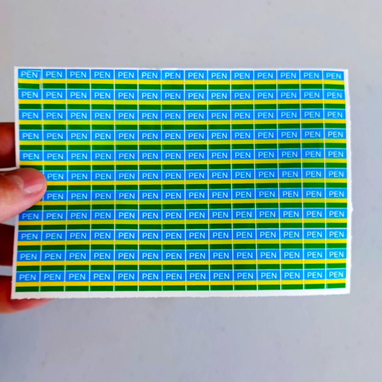 Blue and green PEN electrical component labels on a sheet, designed for safety and organization in electrical systems.