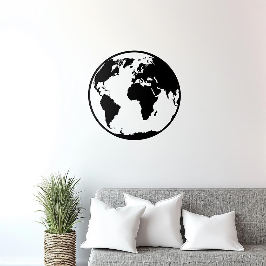Minimalist black globe wall decal on white wall above a gray couch with decorative pillows and a potted plant.