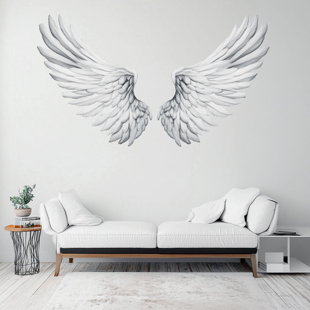 Elegant large angel wings wall decal in minimalist living room decor with white sofa.