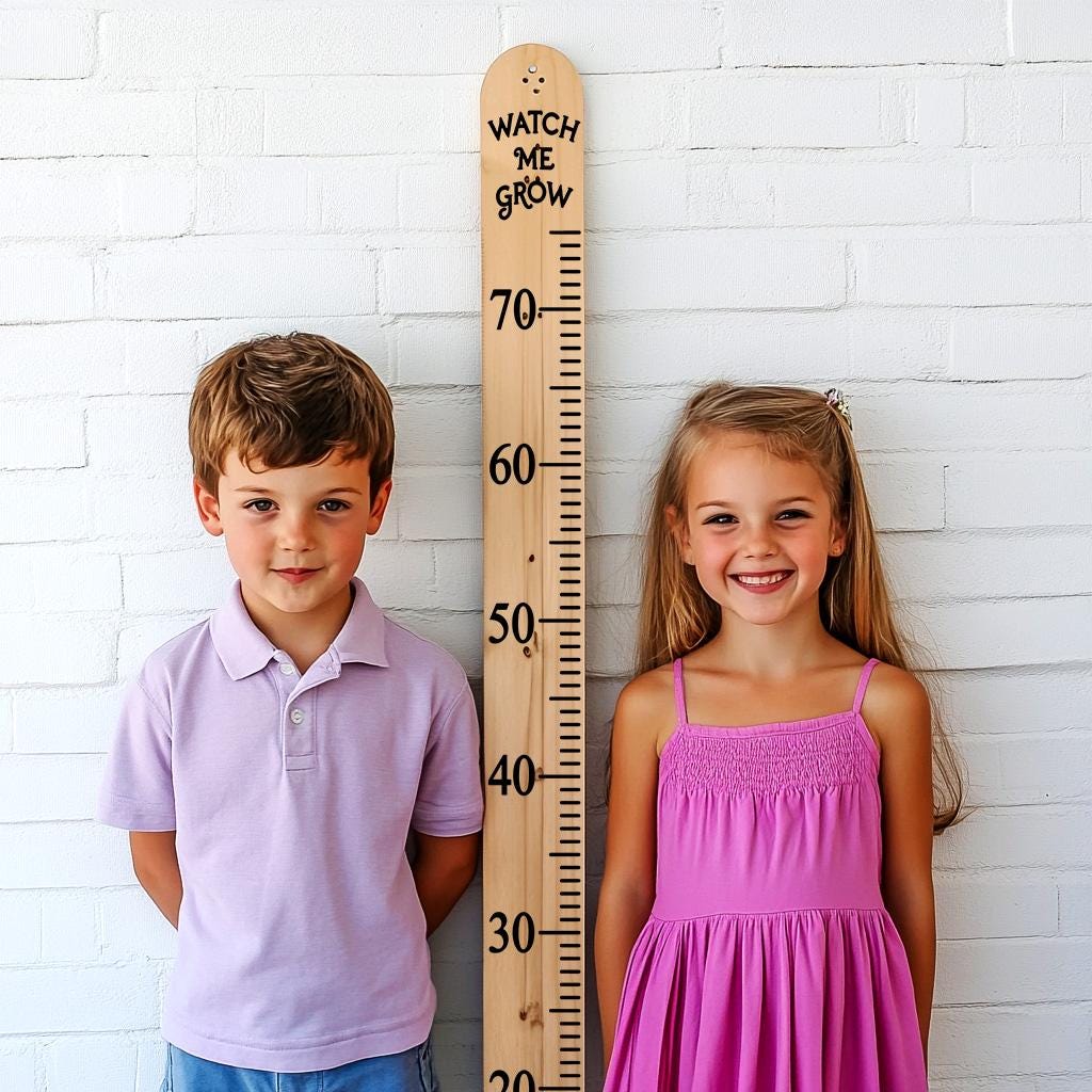 Two kids smiling beside a height growth chart decal marked in inches, showcasing a playful way to track growth.