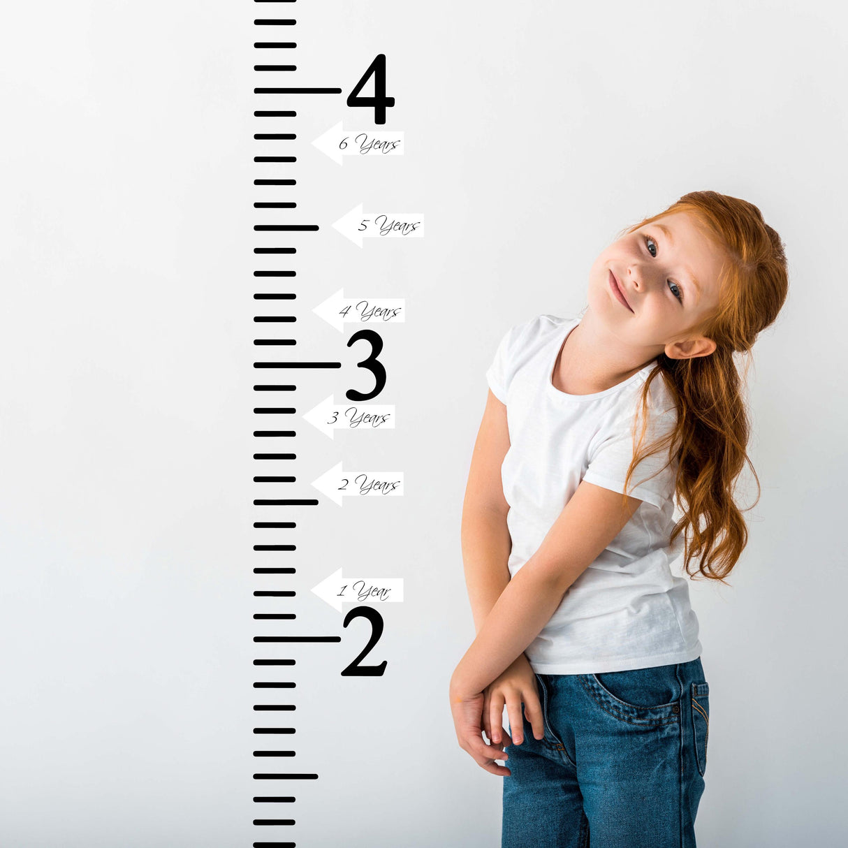 Smiling child beside a growth chart ruler vinyl wall decal with height markers and arrow stickers.