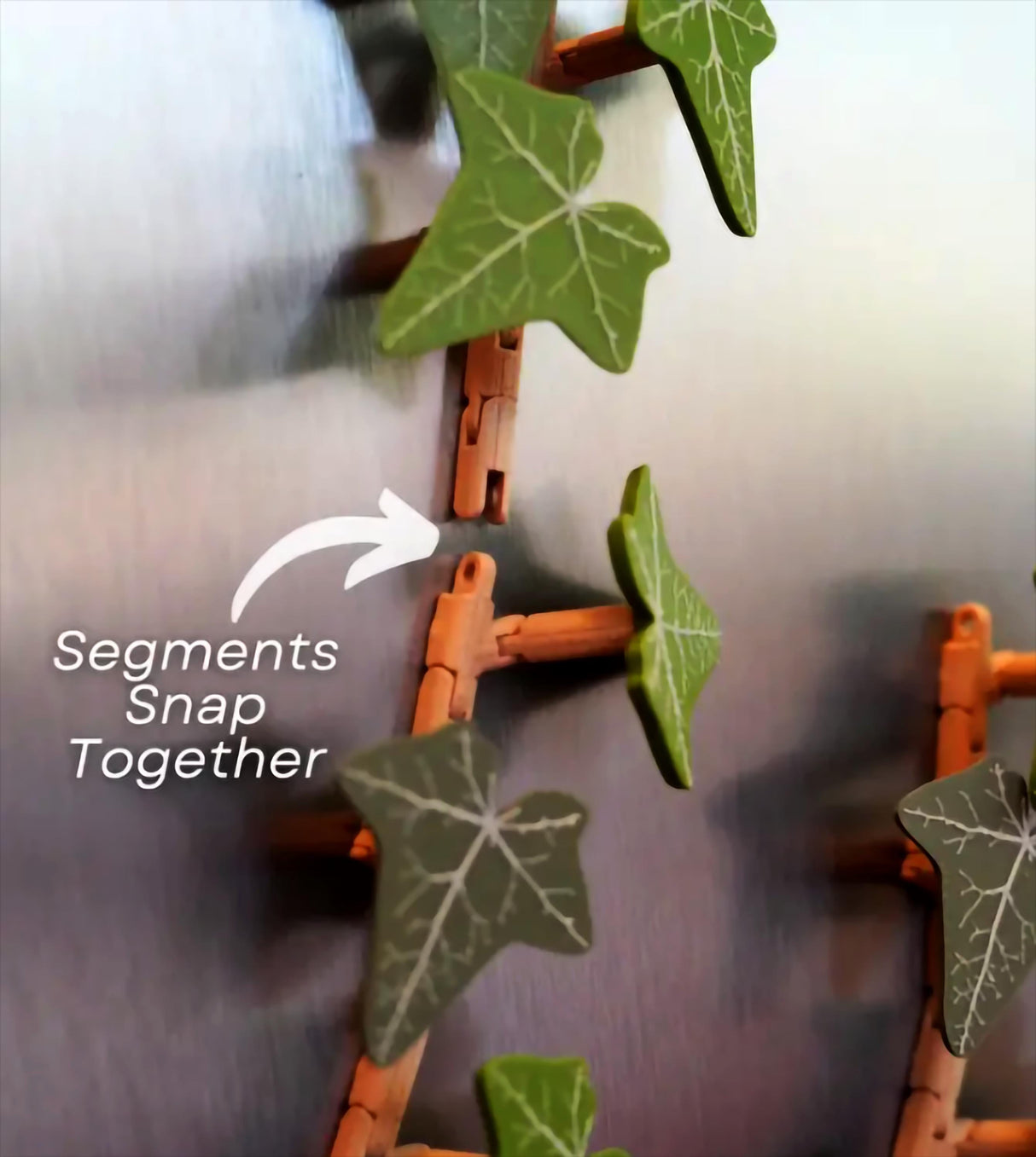 Flexible segments of the custom ivy fridge magnet snapping together, showcasing its articulated design.
