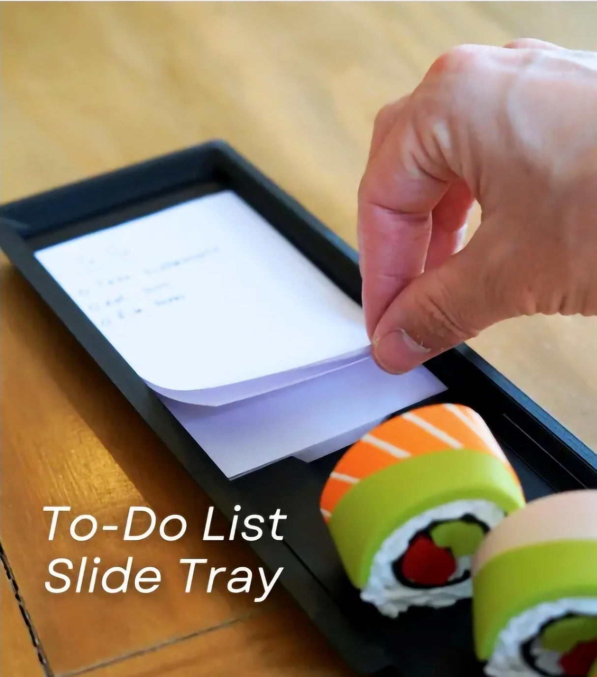 Person using a sushi-themed slide tray for a to-do list with colorful sushi containers.