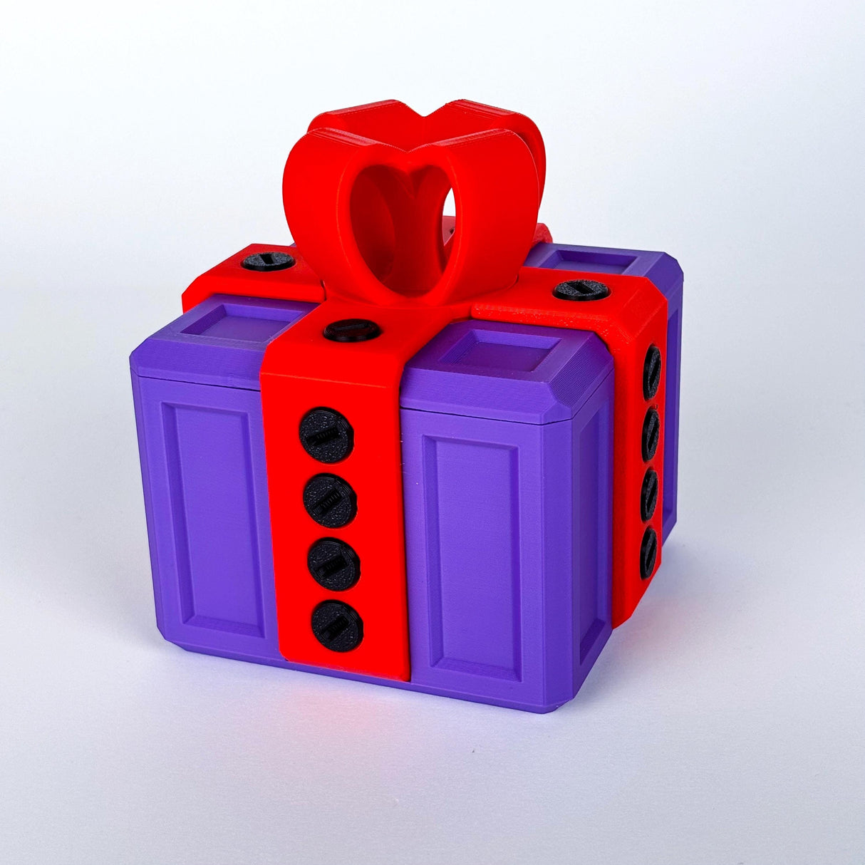Colorful 3D printed Annoying Gift Box with red heart-shaped bow and creative locking mechanism.
