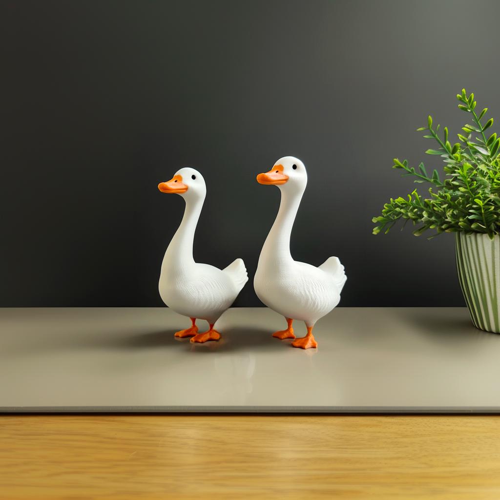 Two 3D printed goose figurines on a table, ideal for home decor and key organization.
