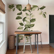 Vertical leaf wall decal sticker in a dining area, featuring green branches on a pink wall, adding a nature-inspired touch.