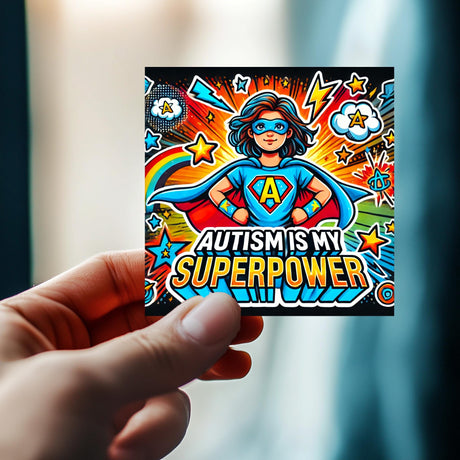 Colorful "Autism Is My Superpower" vinyl sticker held in hand, featuring a superhero girl design for autism awareness.