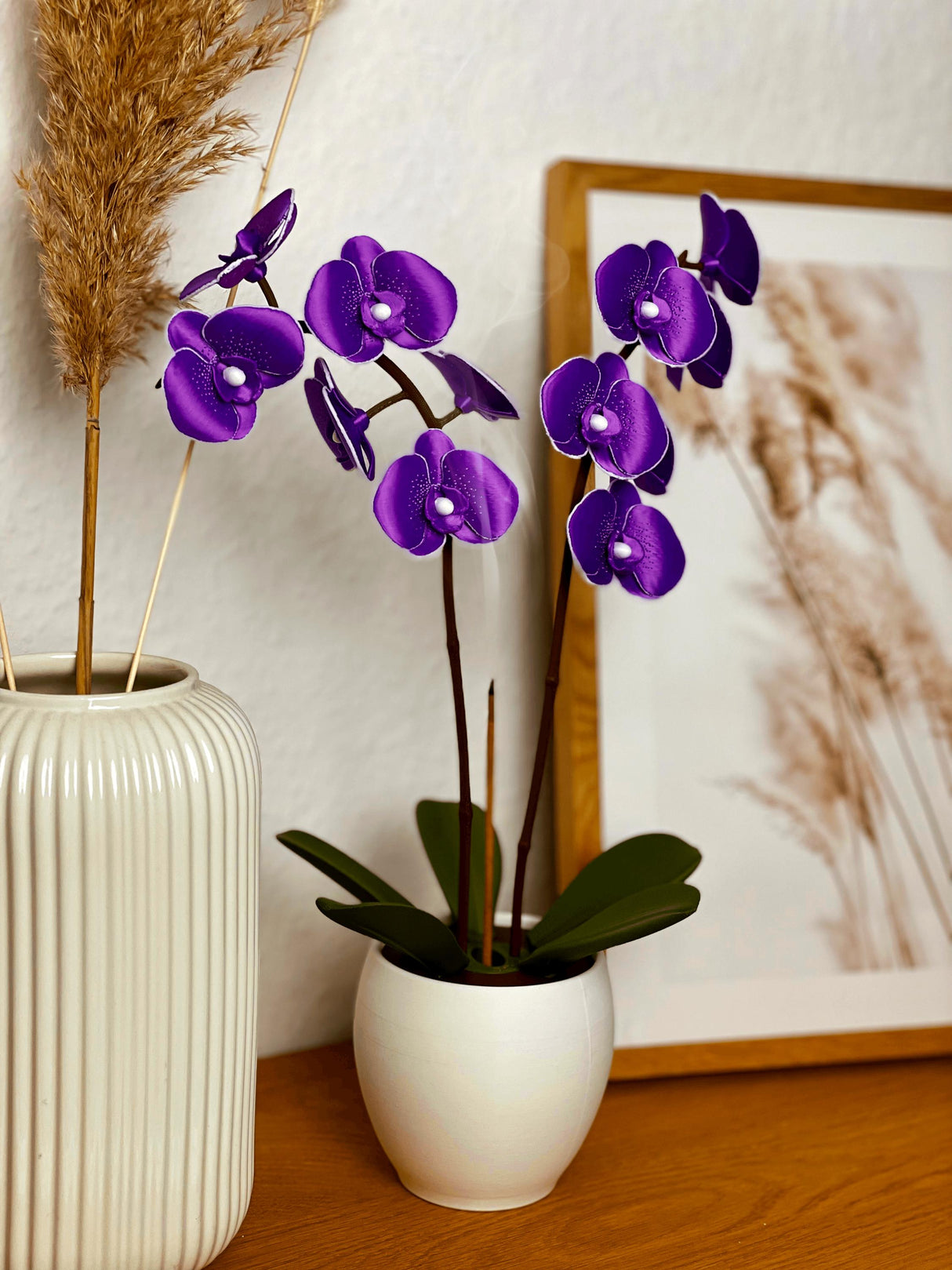 Aromatic orchid oil diffuser featuring vibrant purple blossoms in a stylish white pot, enhancing home decor.