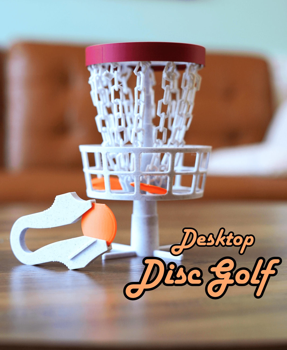 Mini desktop disc golf basket with orange disc for trick shot practice and office desk activity.
