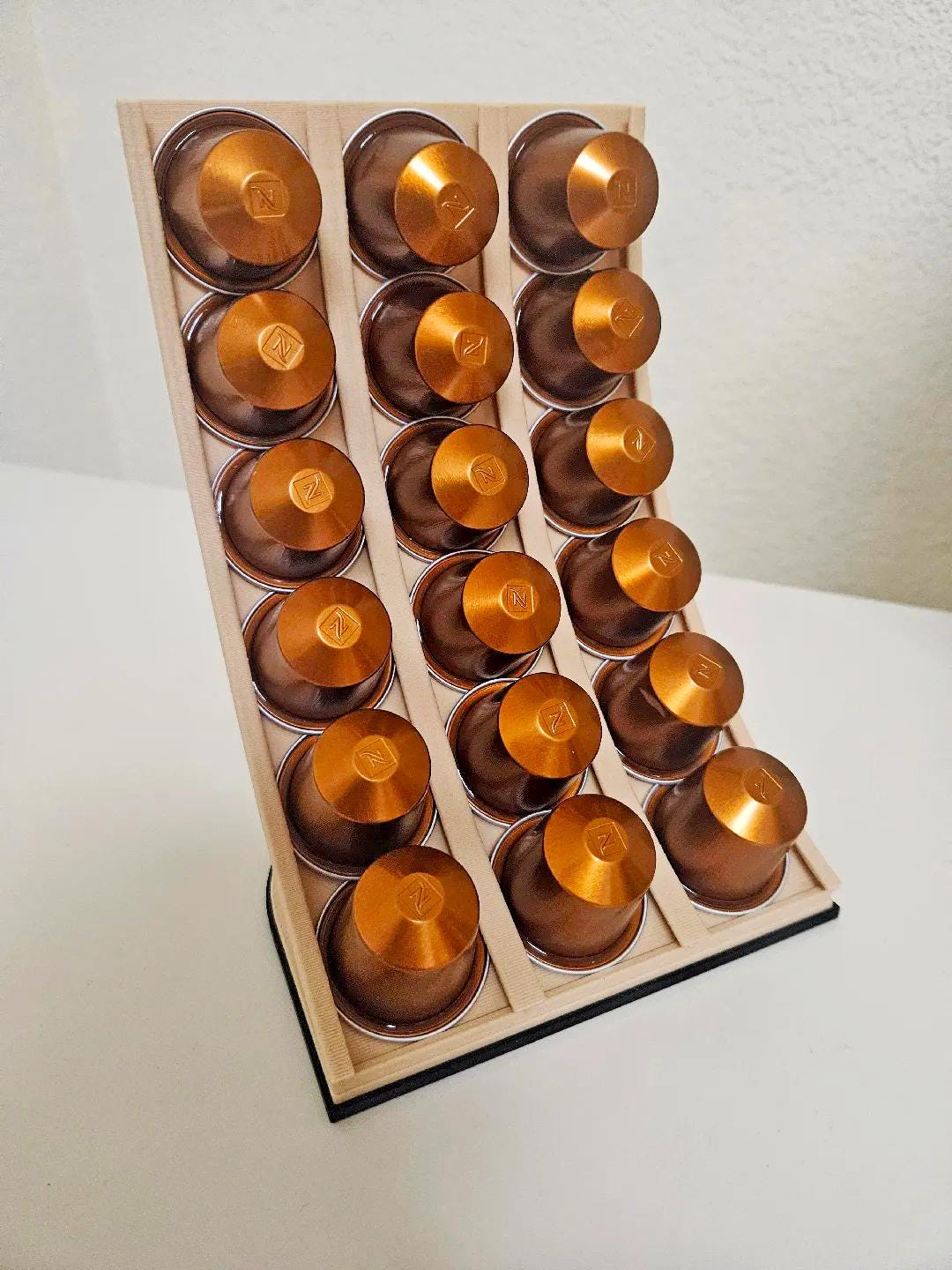 Nespresso coffee capsule holder displaying neatly organized coffee pods in a modern 3D-printed design.