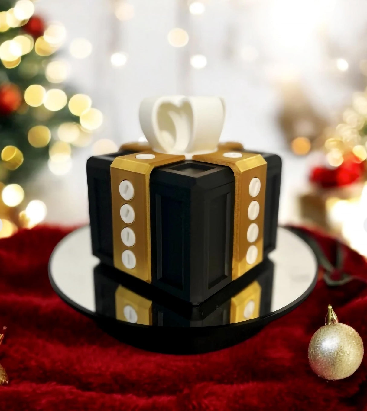 3D-printed Annoying Gift Box in black and gold design on a reflective surface, perfect for prank gifts and unique packaging.