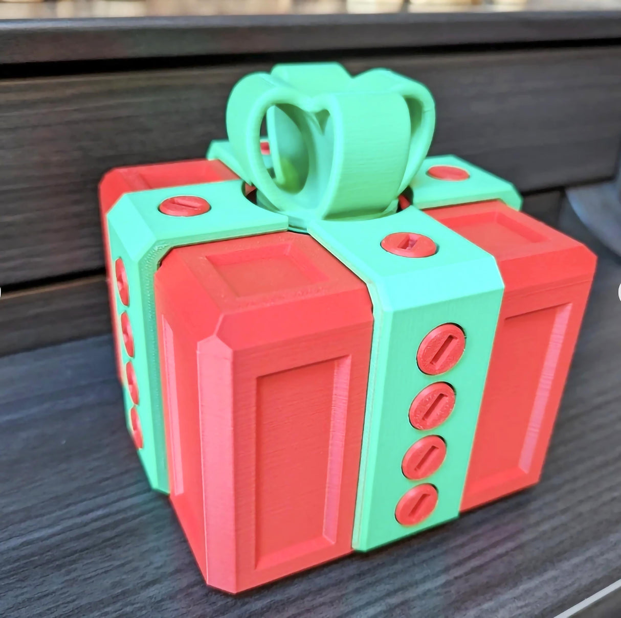 Colorful 3D printed Annoying Gift Box with red and green design, featuring locking bolts for a fun gifting challenge.