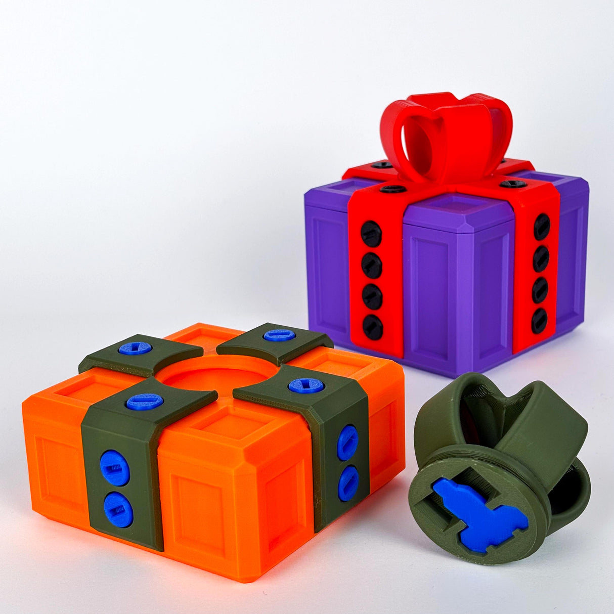 Mini Annoying Gift Box set featuring colorful 3D printed puzzle gift boxes in orange, purple, and red with locking mechanisms.