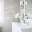 Elegant Chinoiserie blossom wall decal in light gray bathroom with a white vanity and fresh flowers.