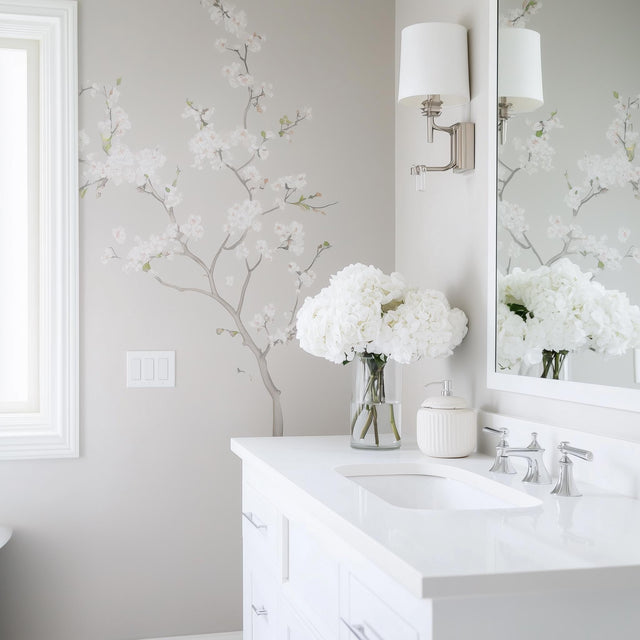 Elegant Chinoiserie blossom wall decal in light gray bathroom with a white vanity and fresh flowers.