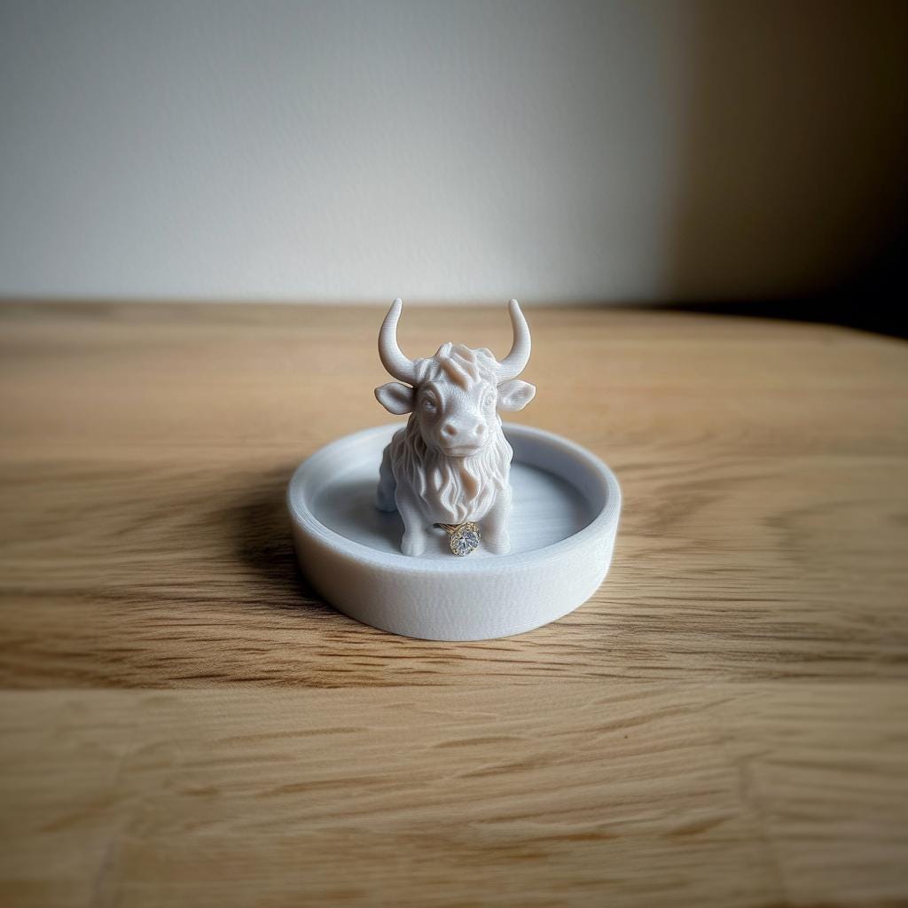 3D-printed Highland cow jewelry dish with rings, farm-inspired trinket tray on wooden surface.
