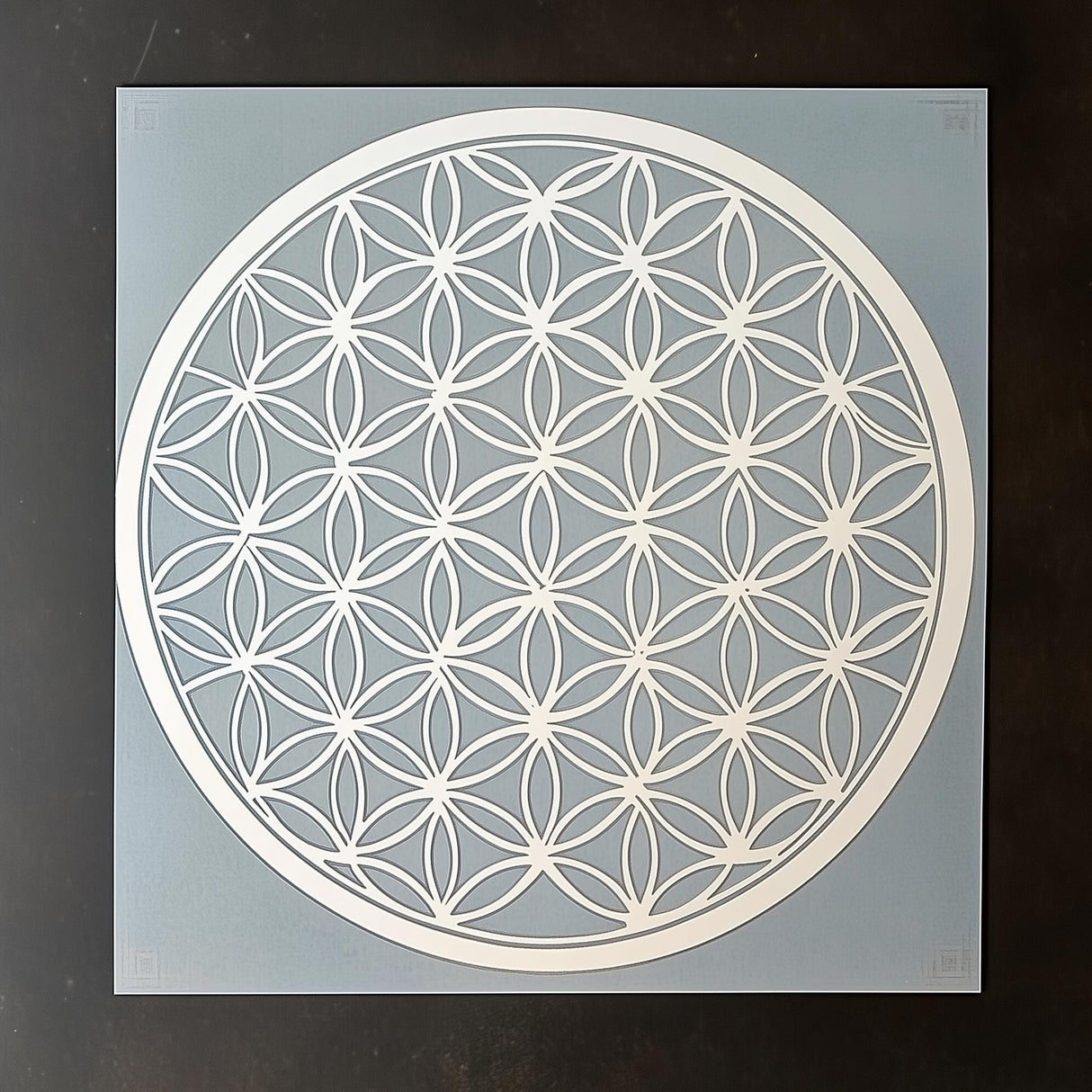 Flower of Life stencil design on a blue background, perfect for DIY home decor and crafting projects.
