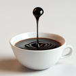 Floating coffee drop sculpture in a white cup, showcasing an optical illusion of coffee splashing.