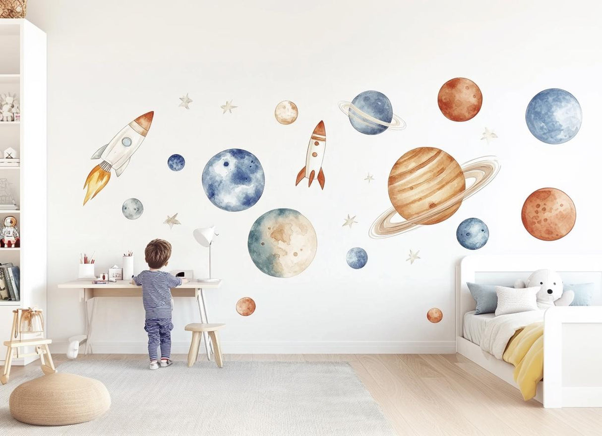 Child admiring watercolor space wall decals of planets and rockets in a cozy, artistic nursery.