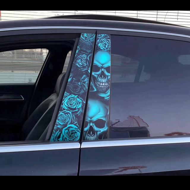 A close-up of a black car featuring two vivid vinyl decals on the B-pillars, showing a detailed blue skull and rose pattern with multiple skulls stacked vertically across both panels.