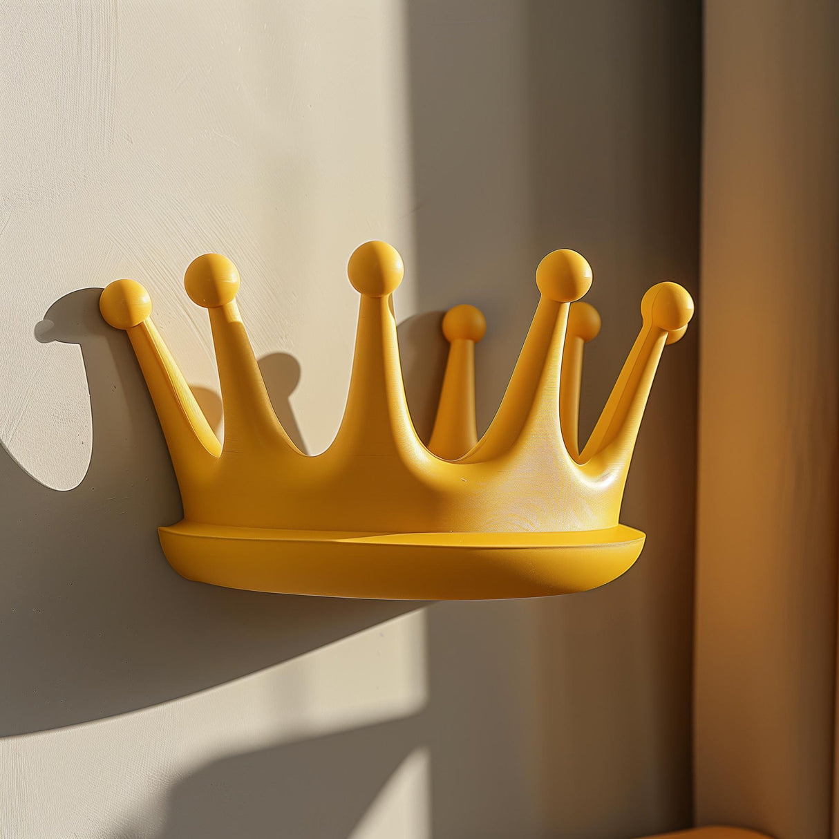 3D printed yellow crown-shaped wall shelf made from matte PLA, used as a small floating ledge in a sunlit kids’ room interior.