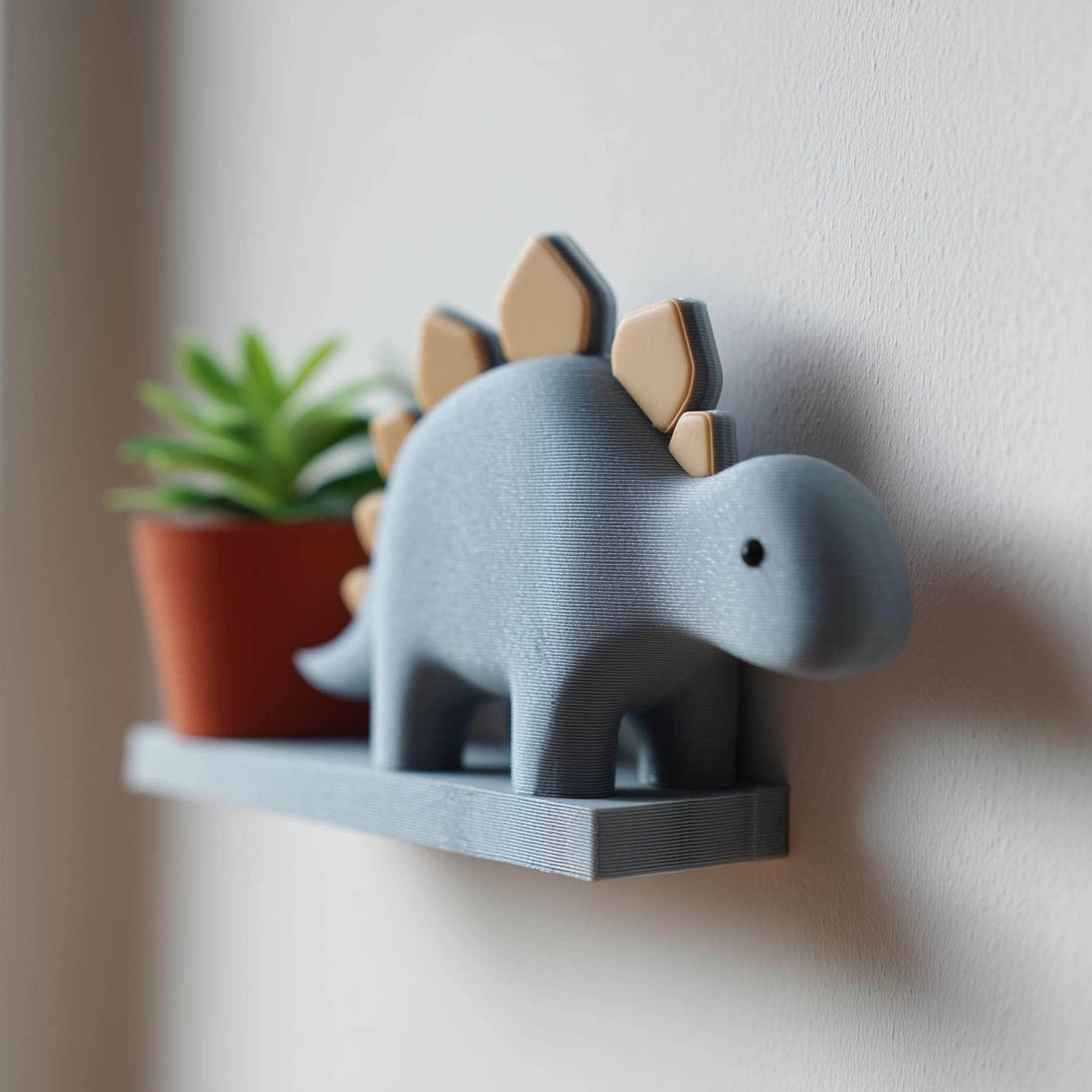 3D printed wall shelf shaped like a cute stegosaurus with a small ledge, holding a plant pot, mounted on a light wall in a kids’ room.