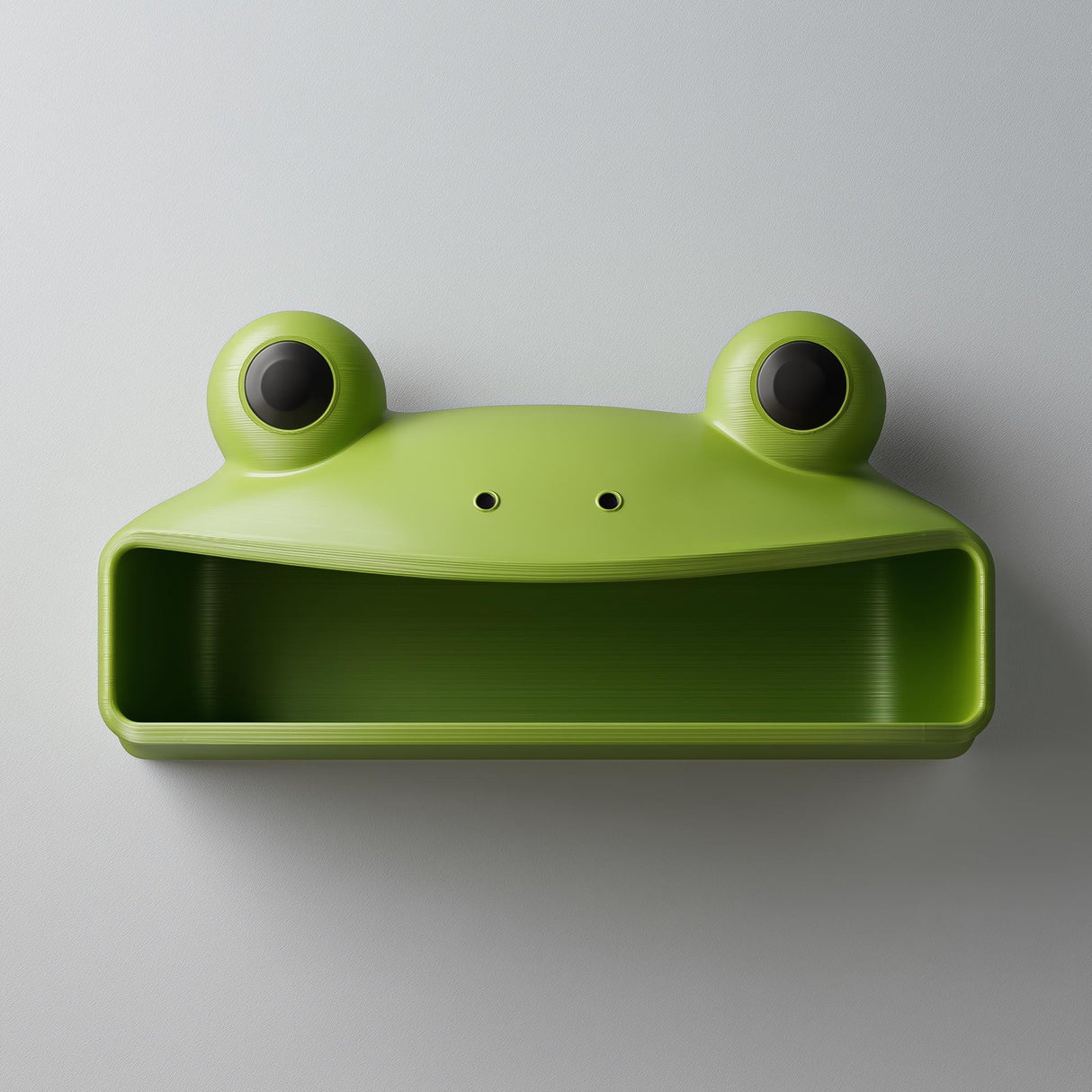 3D printed cute frog wall shelf with big round eyes and open storage compartment, mounted on a light modern interior wall.