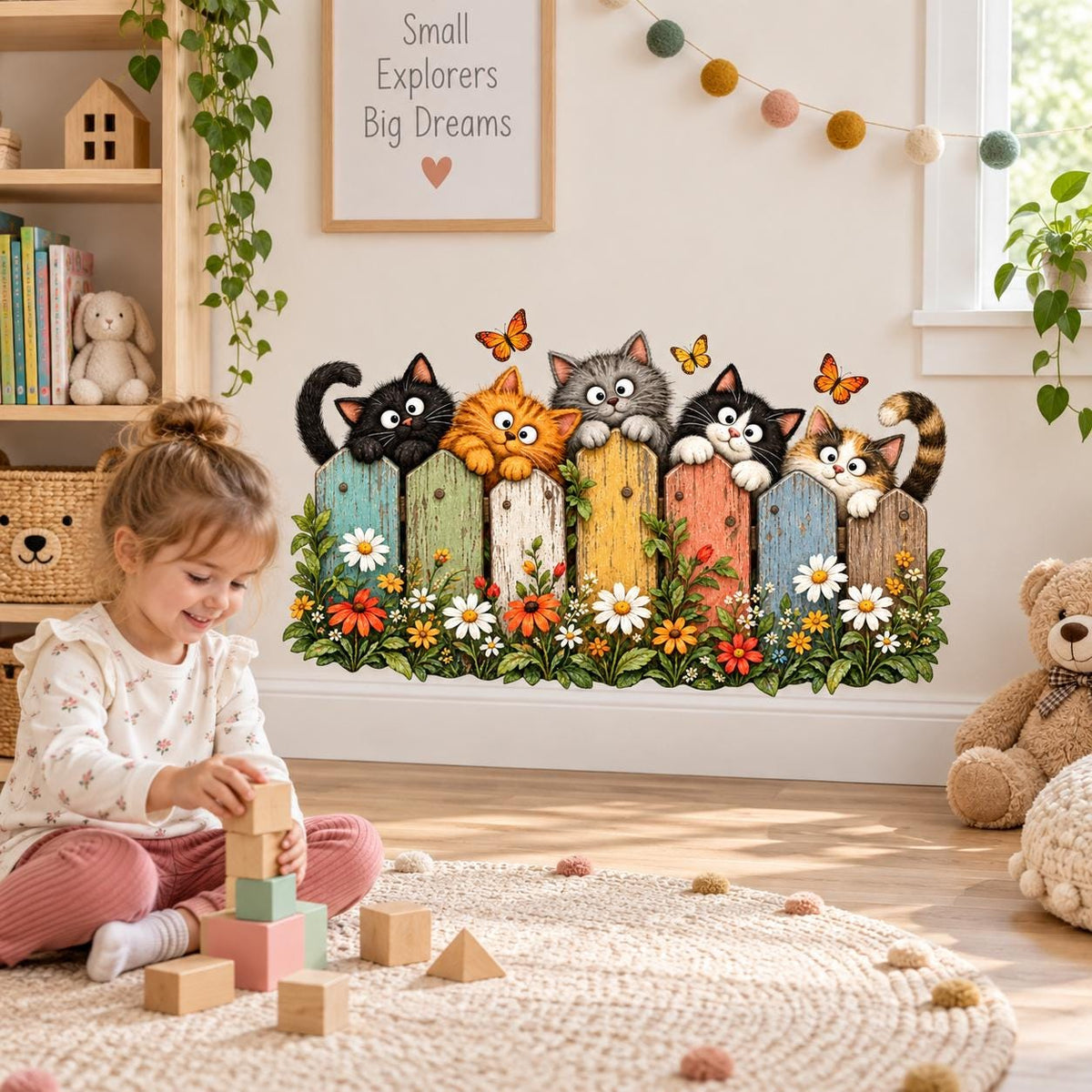 Cat lover wall art featuring five cats peering over a bright wooden fence with daisies and leafy plants.