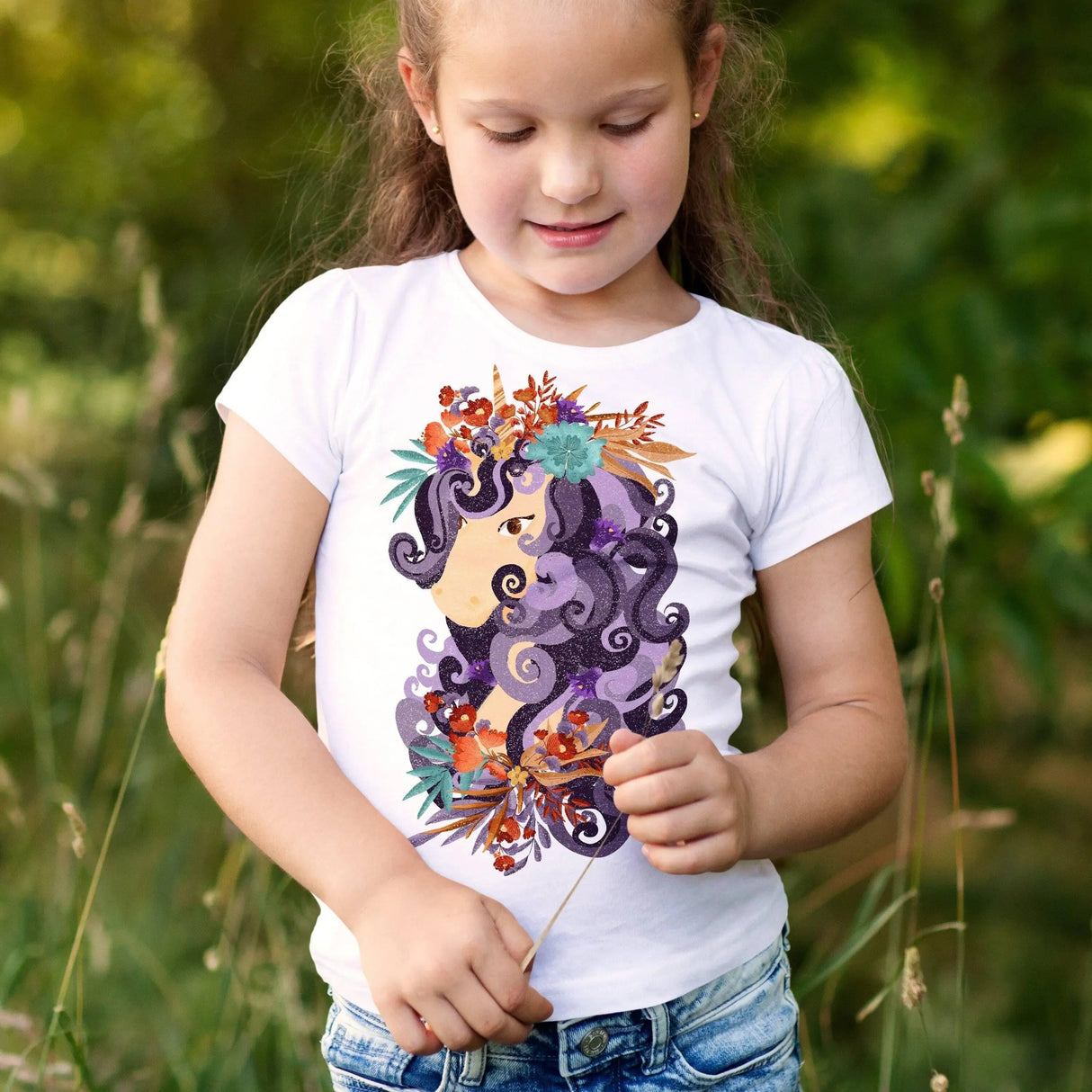 Girl wearing a personalized white t-shirt with a colorful floral and hair design, enjoying nature outdoors.