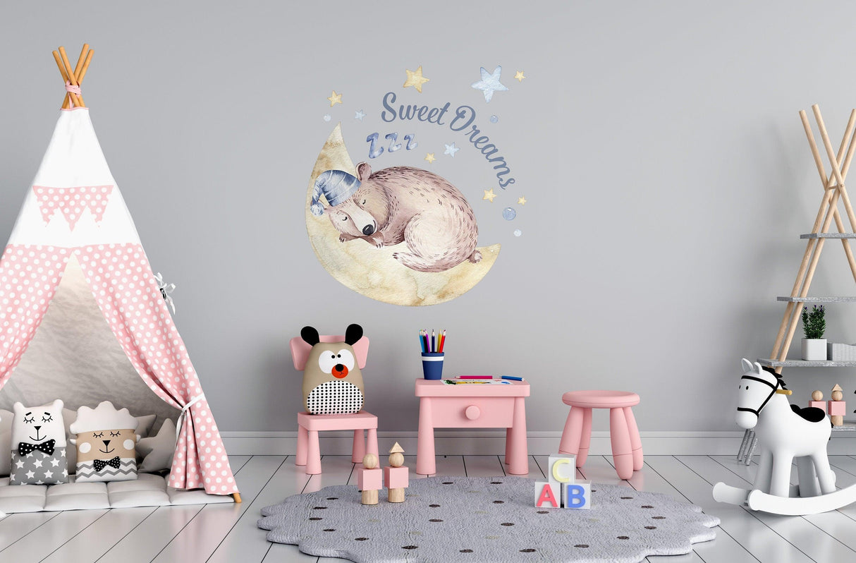 Whimsical nursery room with bear wall decal saying 'Sweet Dreams', pink furniture, and a teepee for kids.