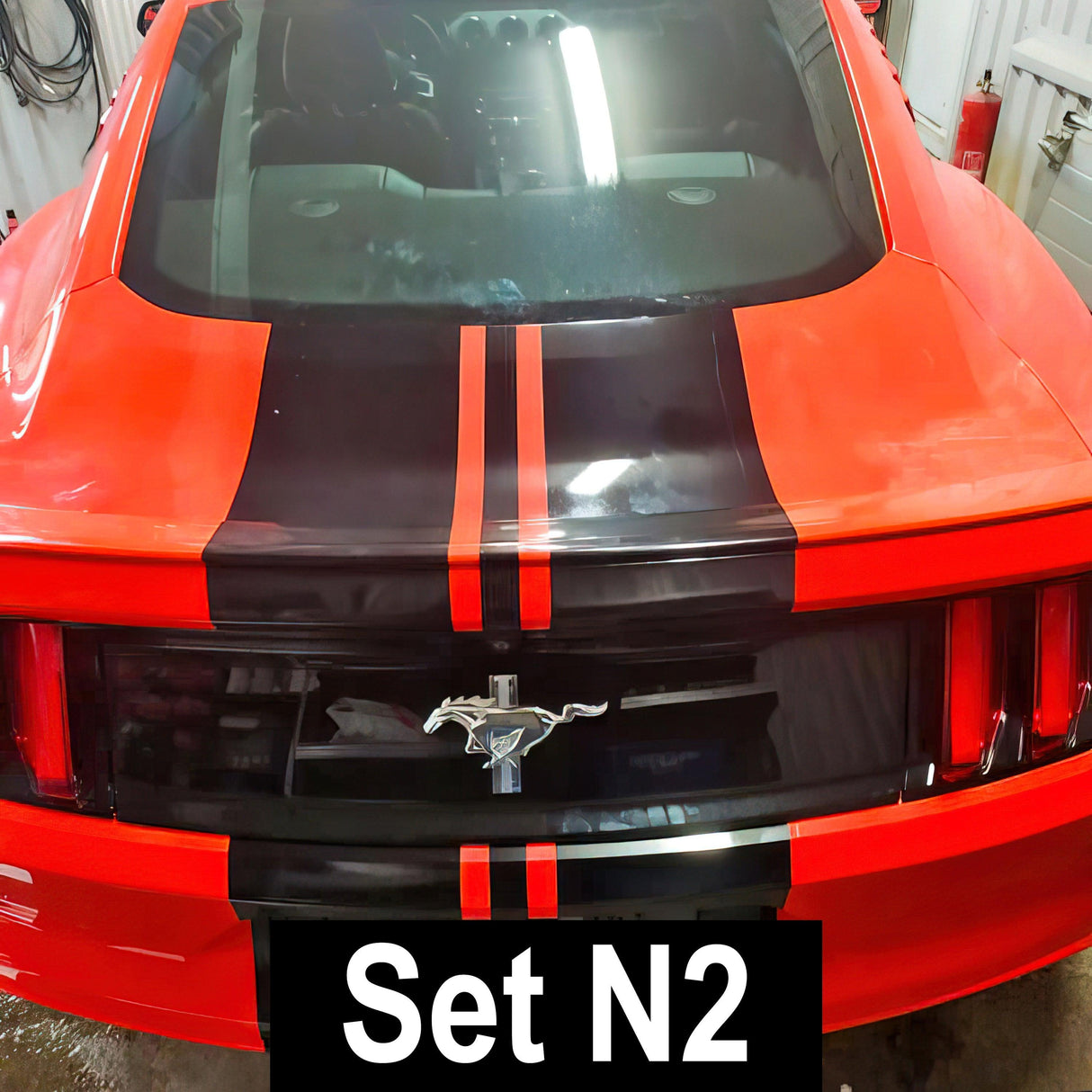 Racing stripes vinyl decals on a red car, showcasing a sporty look and enhancing vehicle style.