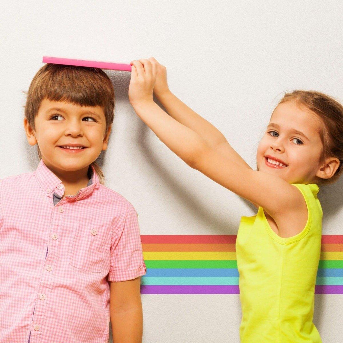 Kids enjoying a colorful rainbow stripe sticker on a wall, adding fun to their playful space.
