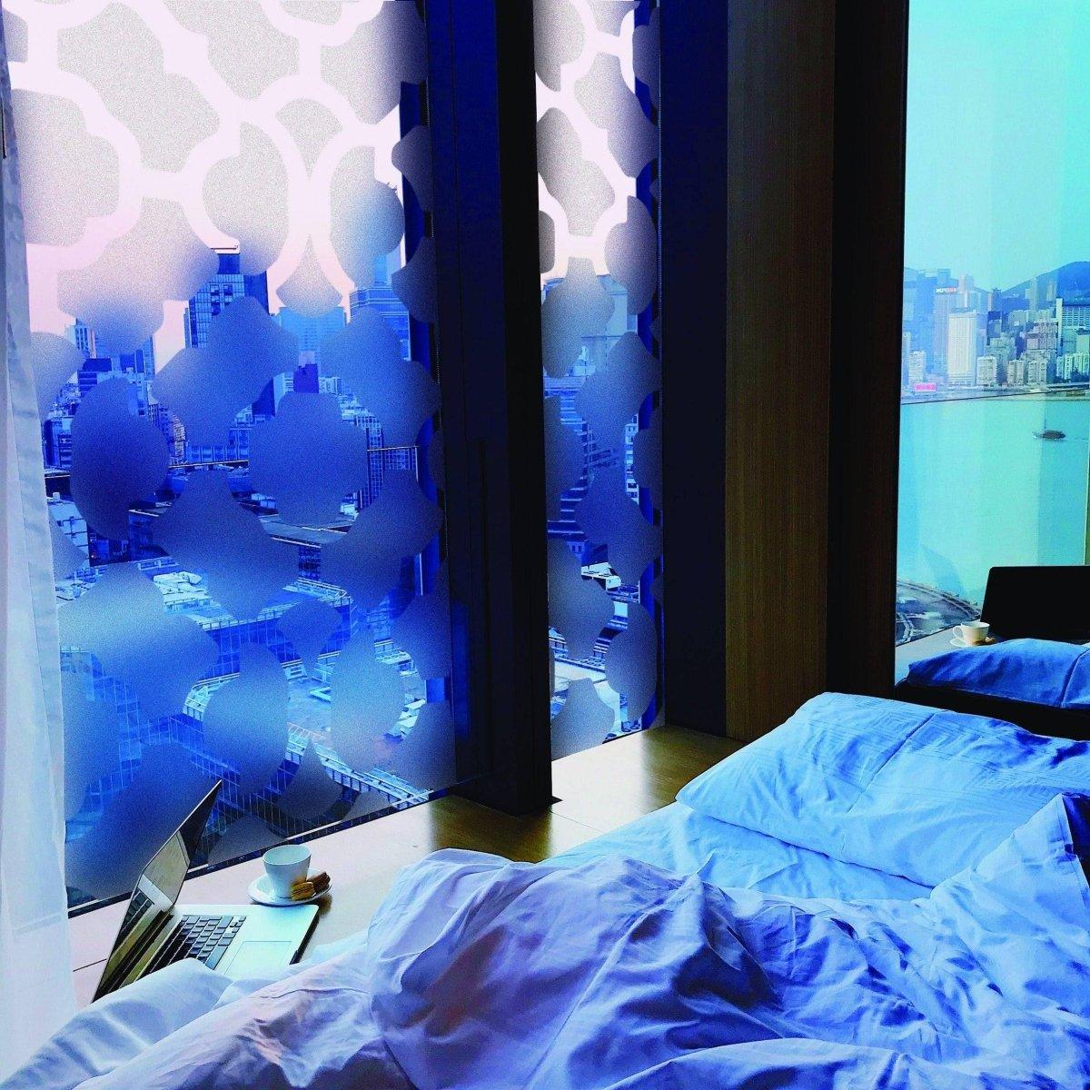 Stylish frosted privacy window film in a modern bedroom with city views, offering both elegance and functionality.