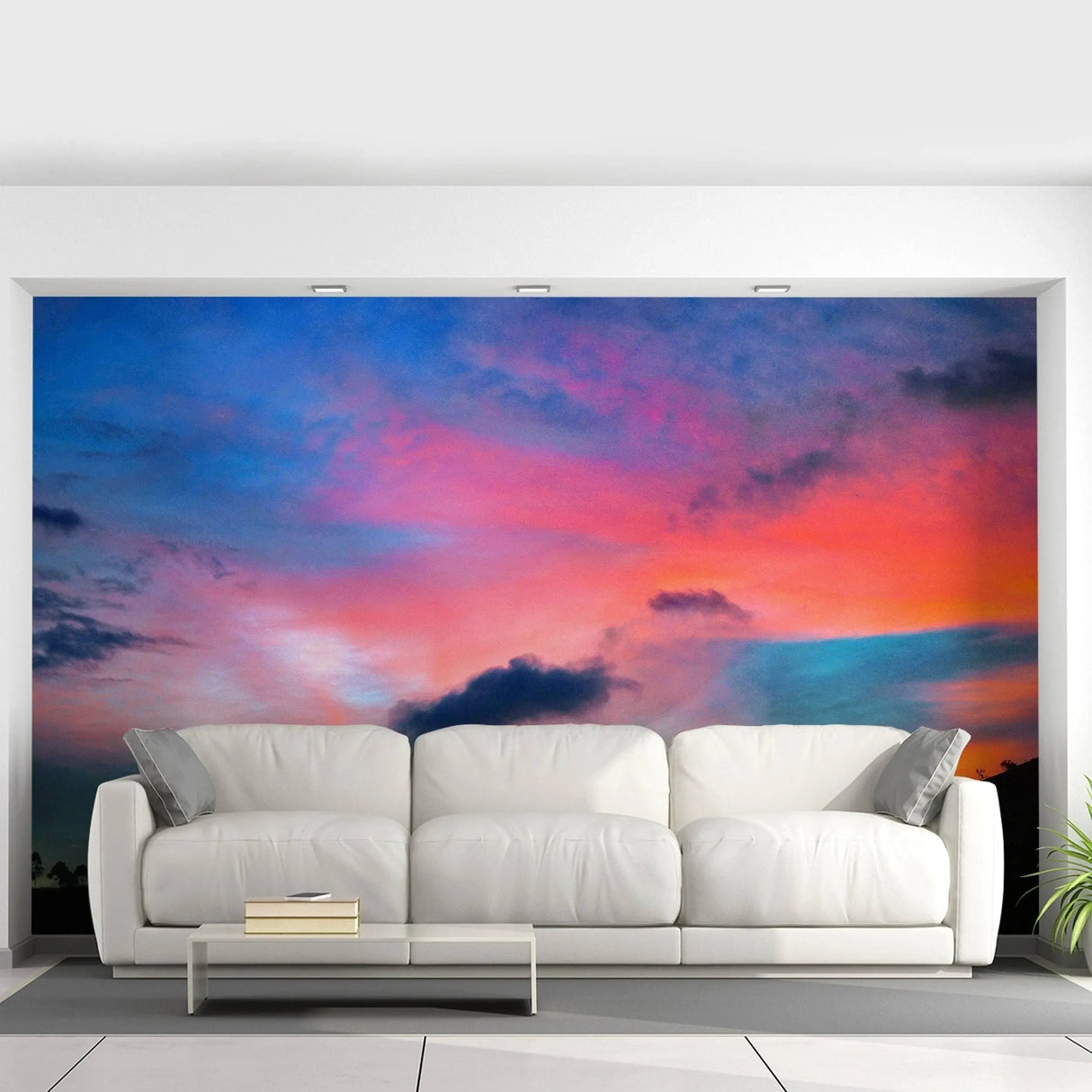 Stunning sunset wall mural above a modern white couch in a stylish home interior.