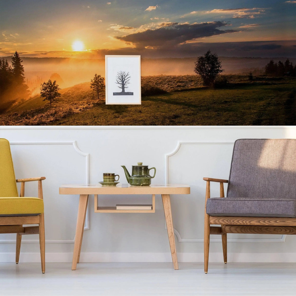 Living room with sunset wall decal, featuring seating and a tea set for a peaceful ambiance.